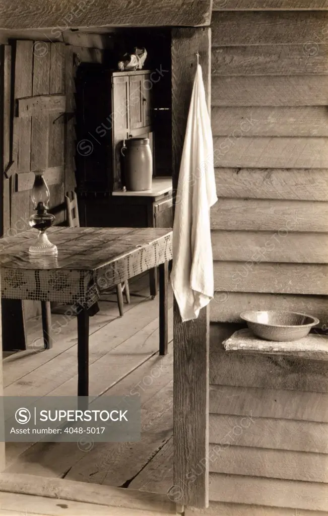 A washstand in the dog run and view into the kitchen in the home of Floyd Burroughs, cotton sharecropper. Hale County, Alabama. Published in the book, 'Let Us Now Praise Famous Men'. photograph by Walker Evans, 1936.