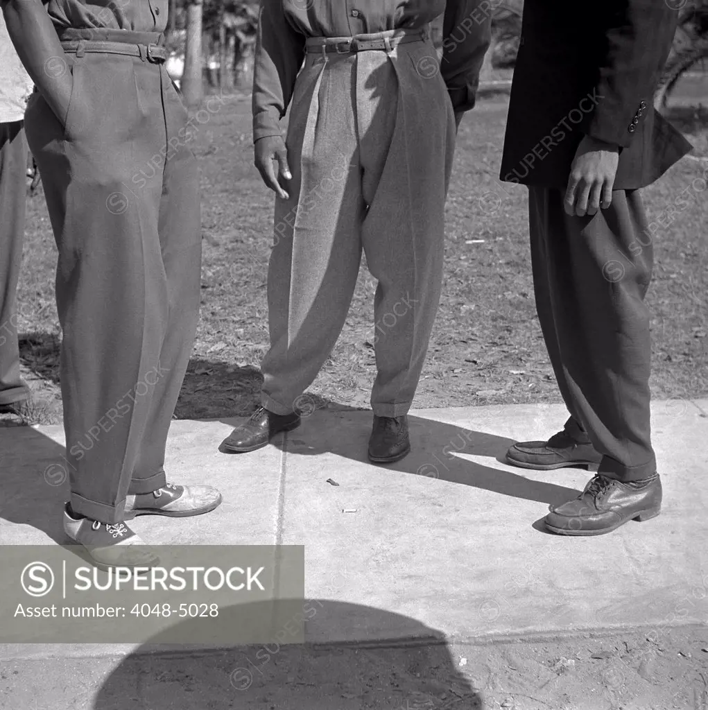 The 'Zoot Suit' styled trousers, called tramas, of three African American college students at Bethune-Cookman College.  The high-waisted, wide-legged, tight-cuffed pegged trousers fashion trend thrived in the Latino, and African American youth subcultures during the early 1940's era. January 1943 photo by Gordon Parks.