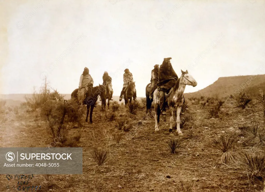 Apaches. Desert rovers- Five Apache on horseback in desert. photo by Edward S. Curtis, 1903