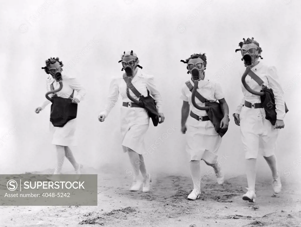 Nurses in gas masks walk through a cloud of smoke in a training drill of the U.S. Army Air Forces Technical Training Command, 1942