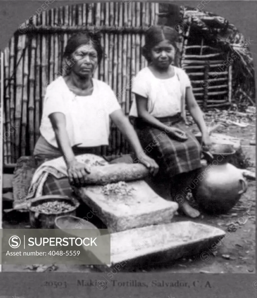 Grinding corn for tortillas with a metate in the streets of Guadalupe, Mexico. 1902