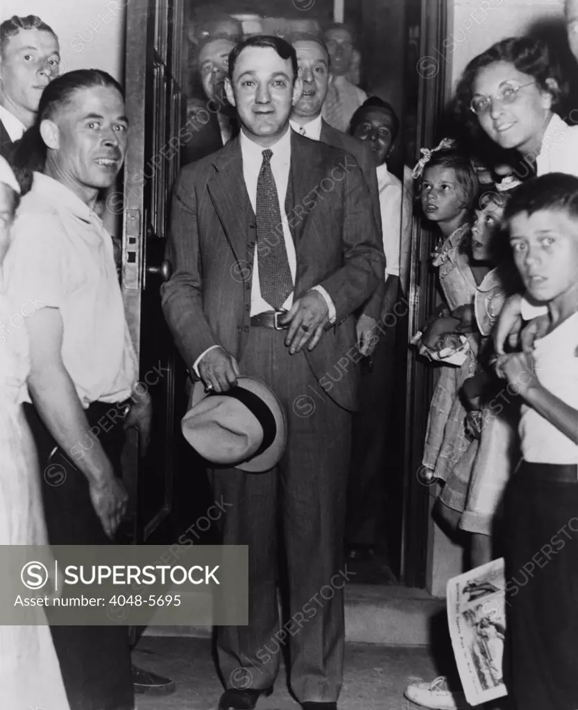Dutch Schultz, emerging from doorway of Malone County jail, in an upstate New York town where he was on trial for federal tax evasion. While he was acquitted by the local jury, his mob overlords lost confidence in him and arranged his assassination. 1936.