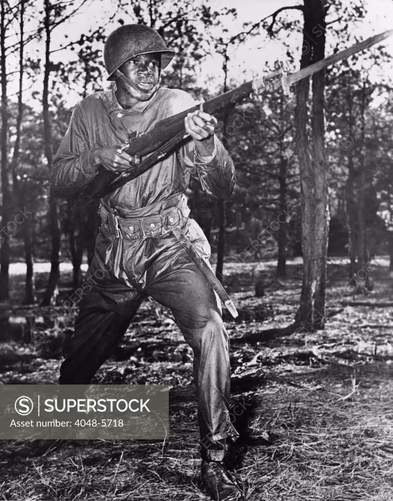 African-American soldier charging with bayonet fixed during World War II combat training at the U.S. Naval training center, Great Lakes, Illinois. Ca. 1942-45.