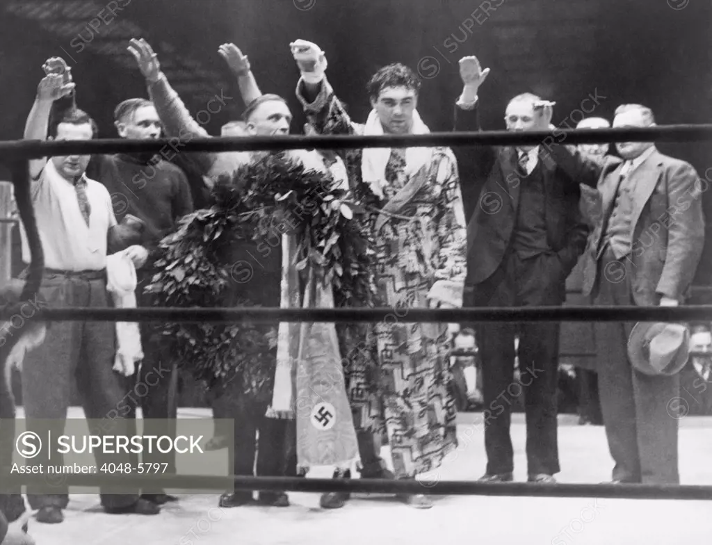 Max Schmeling, with attendants, giving the Nazi salute after his victory over Steve Hamas in Hamburg, Germany, March 10, 1935.