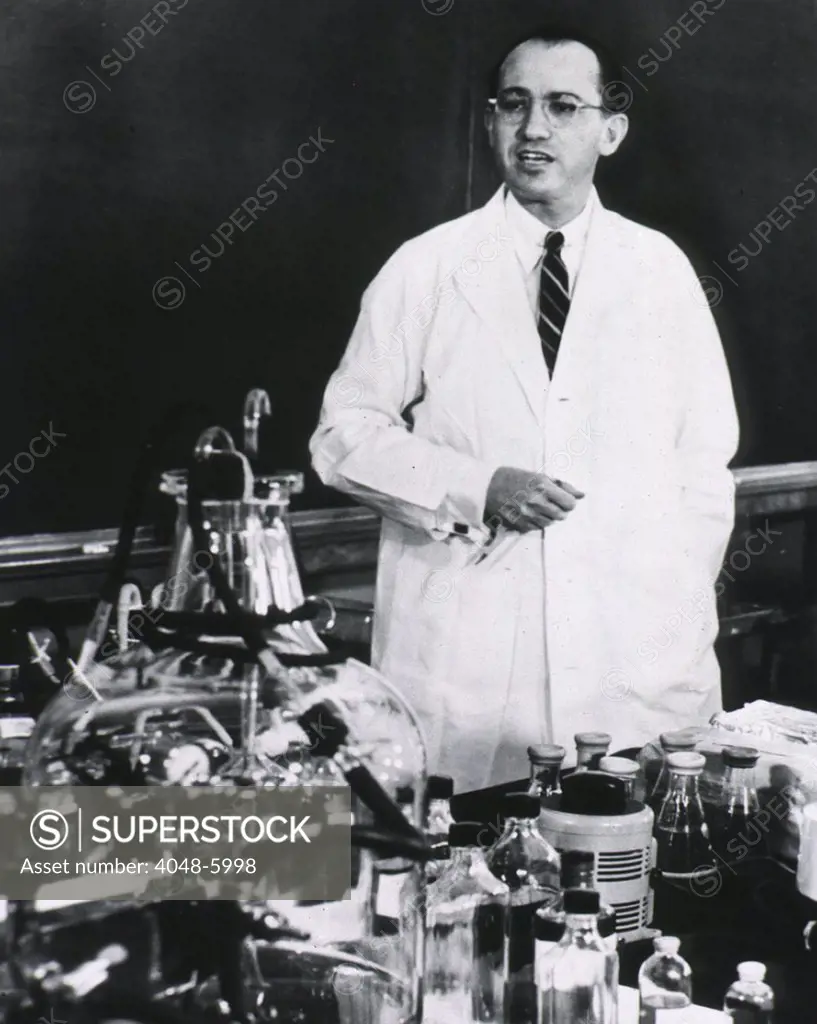 Jonas E. Salk (1914-1995), American developer of the first polio vaccine, standing behind table, lecturing. Ca. 1955.