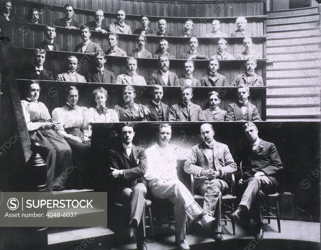 Professors Harvey Cushing, Howard Kelly, Sir William Osler, and William S. Thayer (front row) sit with the graduating class of Johns Hopkins Medical School in the surgical amphitheater. Ca. 1900.