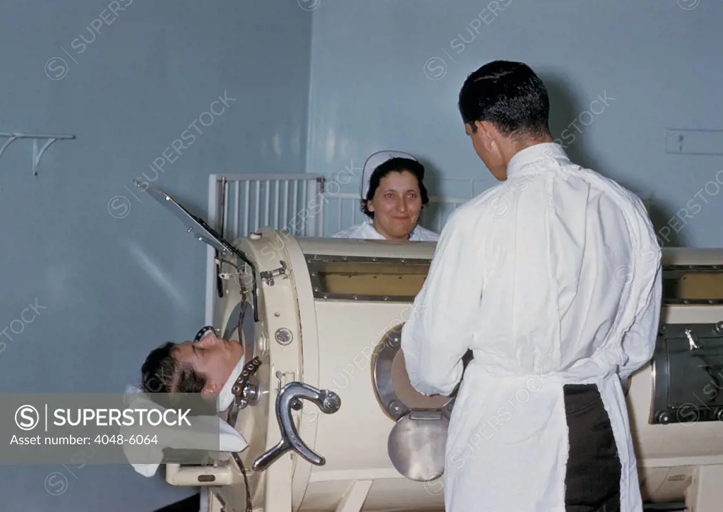 Hospital staff are examining a patient in a tank respirator