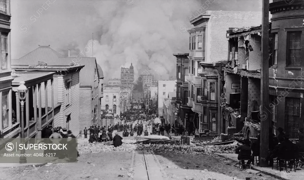 AFTER THE EARTH QUAKE, SAN FRANCISCO. Observers in chairs amid the debris on Sacramento Streetwatch the city burn. The fires, many caused by ruptured gas lines, lasted for 3 days and  were more destructive than the earthquake and its aftershocks. Photo by Arnold Genthe.