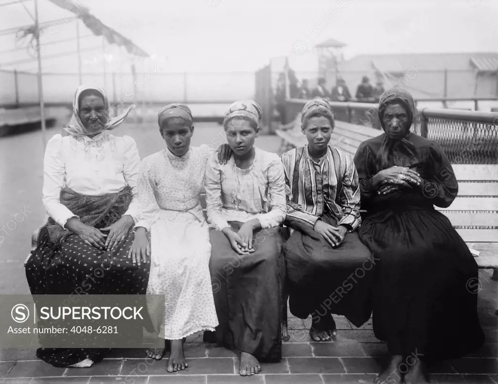 Barefoot women immigrants at Ellis Island are from the Caribbean. Ca. 1910.