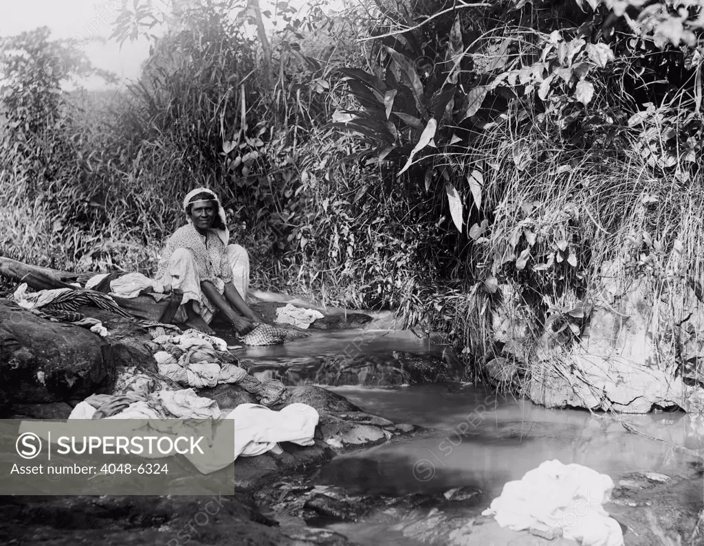 Puerto Ricans women washing laundry in an open stream shortly after Puerto Rico was annexed by the United States after the Spanish American war. Ca. 1903
