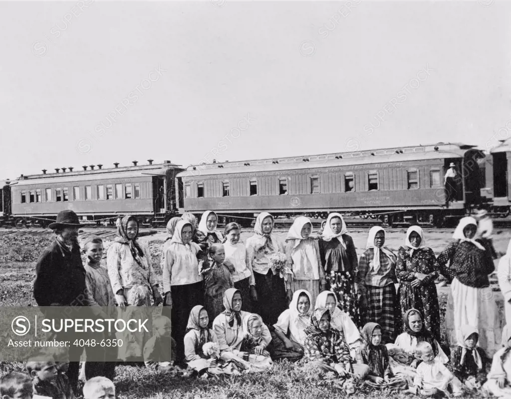 Russian men, women, and children in traditional dress posing in near a passenger train in a Siberian field. In 1906 the Russian government encouraged farmers to emigrant to Siberia. Settlers were given land, transportation and loans to start their farms. From 1897-1914 the Siberian population grew by 73%. Photo ca. 1910.