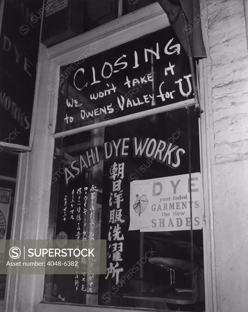 Shop window of the Japanese American owned Asahi Dye Works in Los Angeles' 'Little Tokyo.' The sign reads, 'Closing, we won't take it to Owens Valley for U,' urging customers to pick up their clothes before the Japanese-American owners were interned at Owens Valley Assembly Center. April 1942.