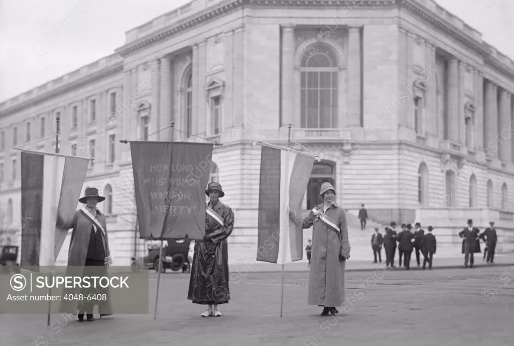Suffragettes picketing the Senate Office Building in Washington in 1918. Left to right: Mildred Gilbert, Pauline Floyd, Vivian Pierce. They display a banner, 'How Long Must Women Wait for Liberty'