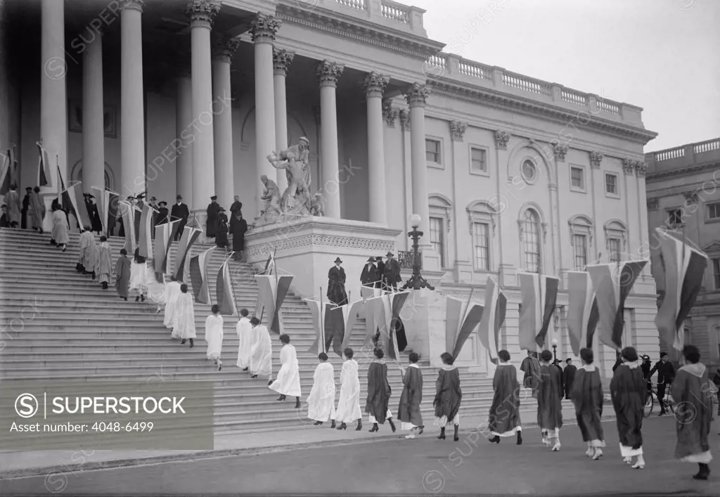 Woman Suffrage demonstration with banners at the U.S. Capitol in 1917. View of Procession ascending Capitol steps.