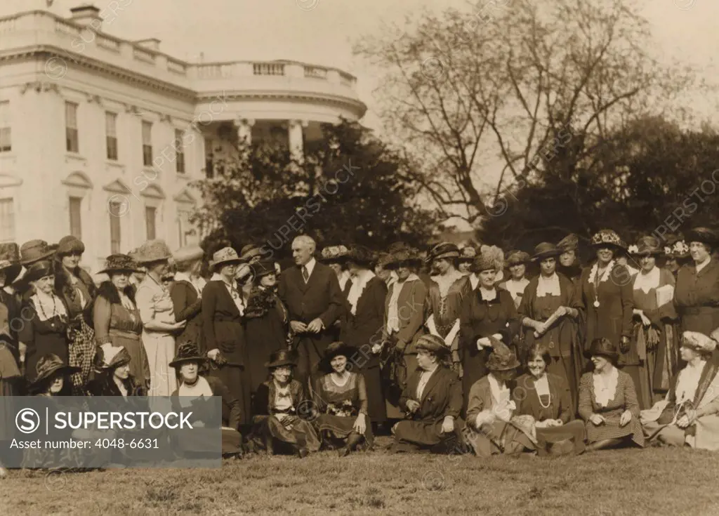 National Woman's Party members with President Harding on the lawn in front of the White House. The women ask the president's aid in passing an 'Equal Rights Bill' in the next Congress. The bill they proposed would give married women citizenship and equal rights of inheritance and contract.