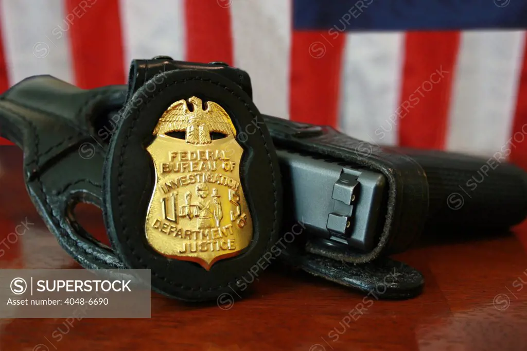 Contemporary FBI badge and gun with American flag.