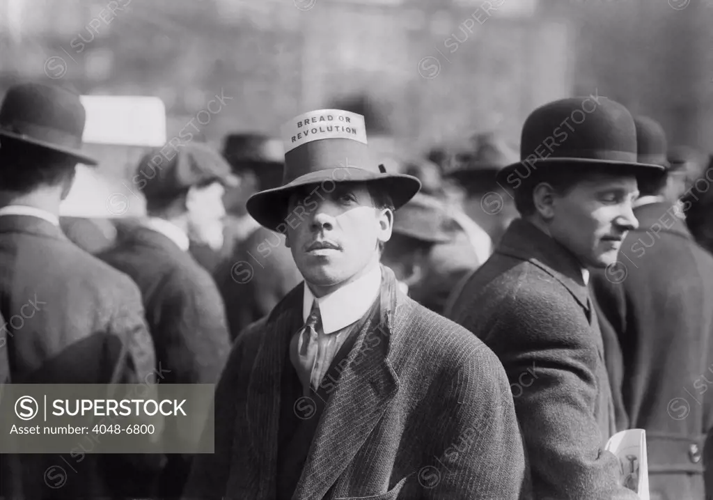 Man wearing a Industrial Workers of the World Hat Card reading 'Bread or Revolution' in a rally at New York City's Union Square. Ca. 1914.