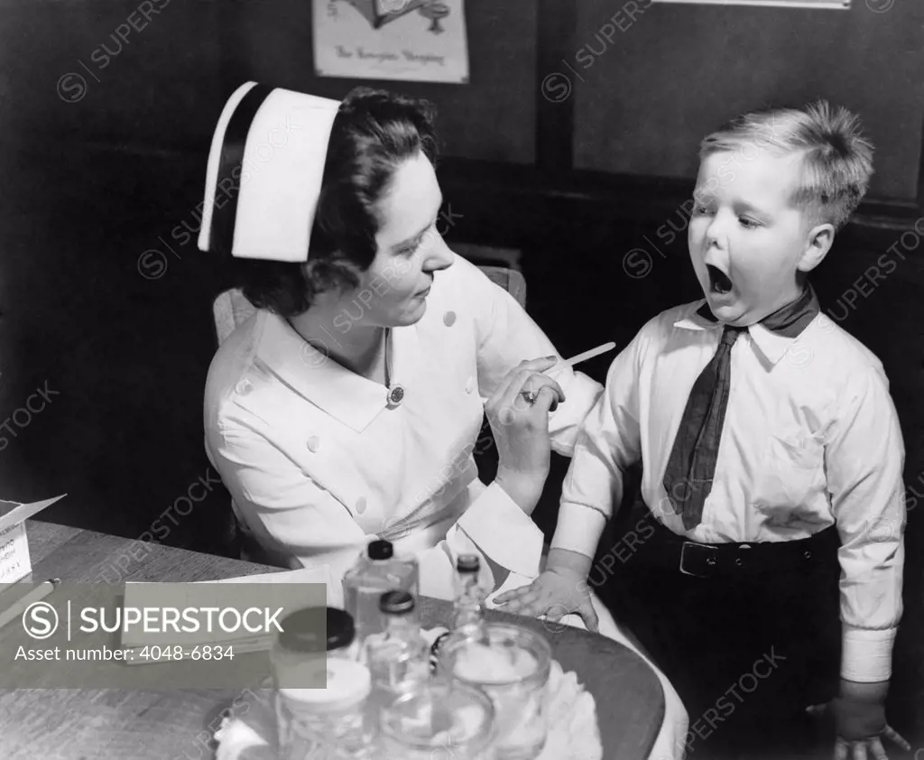 A nurse examining the teeth of a boy in New York, N.Y. , ca. 1935.