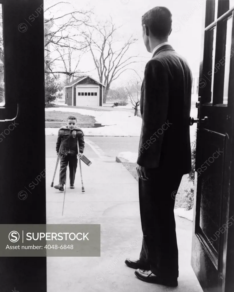 School principal, E. Joseph LaLiberte, waits for seven-year-old polio victim, Eddie Randolph in 1956. 1950s discovery of polio vaccines ended the devastation of the crippling disease.