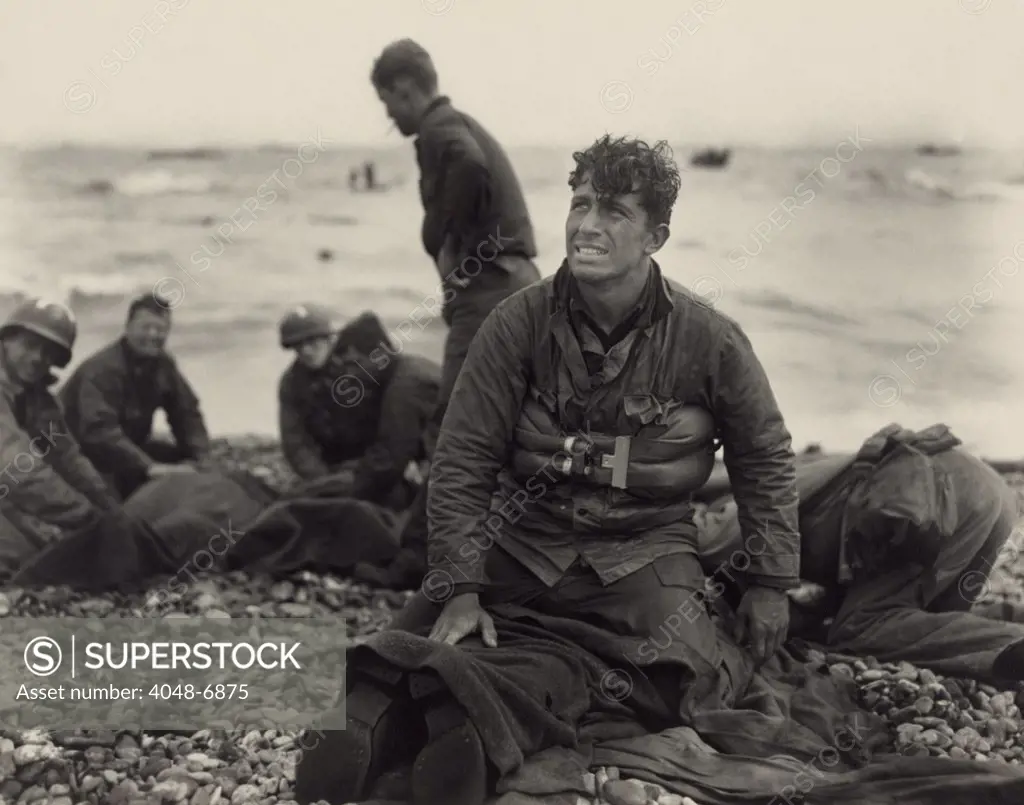 World War II. American soldiers on Omaha Beach recovering the dead after the D-Day invasion of France. June 1944, by U.S. Army Signal Corps photographer, Walter Roseblum.