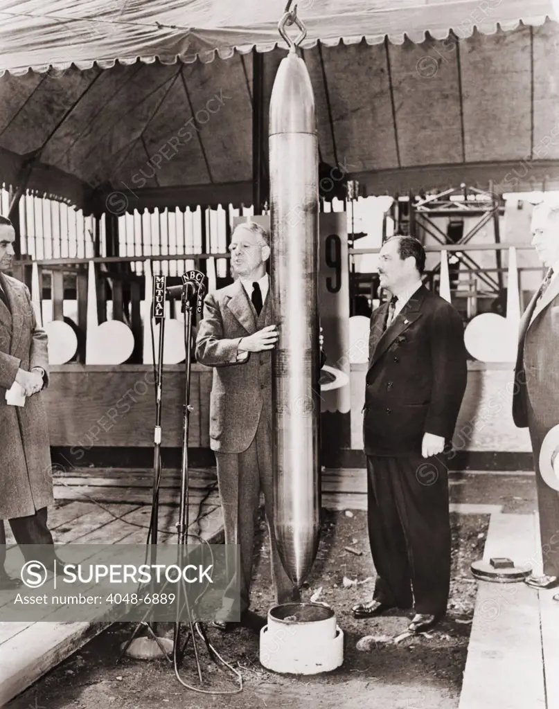 Grover Whalen and A.W. Robertson watching the Westinghouse Time Capsule being lowered into its crypt for 5000 years, at the New York World's Fair in 1938. It was ninety inches long, had a diameter of 6.5 inches, and weighed 800 pounds. It contained everyday items such as a spool of thread and doll, a vial of staple food crop seeds, a microscope, a 15-minute newsreel and microfilm spools of a Sears Roebuck catalog, dictionary, almanac, and other texts.