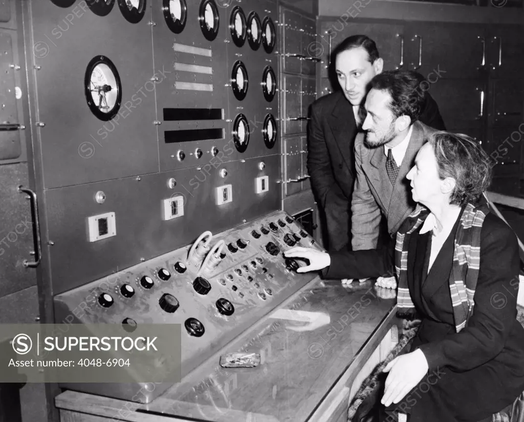 Atomic scientist Irene Curie (1897 -1956), operating the controls of France's first nuclear reactor at Chatillon, a Parisian suburb in 1948. Fellow physicists, Maurice Surdin (1911-2003) and Jean Perrin (1870-1942) look on.