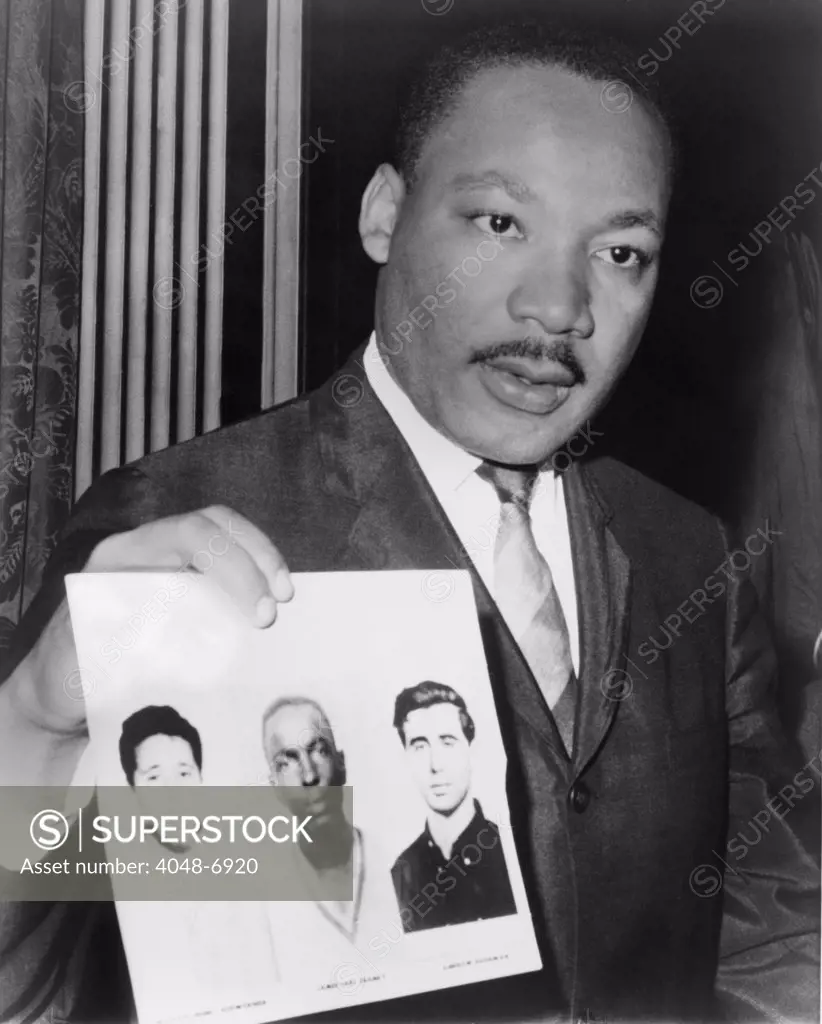 Dr. Martin Luther King (1929-1968), holding photographs of three civil rights workers who were murdered by the Ku Klux Klan: Andrew Goodman, James Earl Chaney, and Michael Henry Schwerner. The 1988 film, MISSISSIPPI BURNING was based on the Federal inverigation of their murders during the 'Freedom Summer' of 1964.