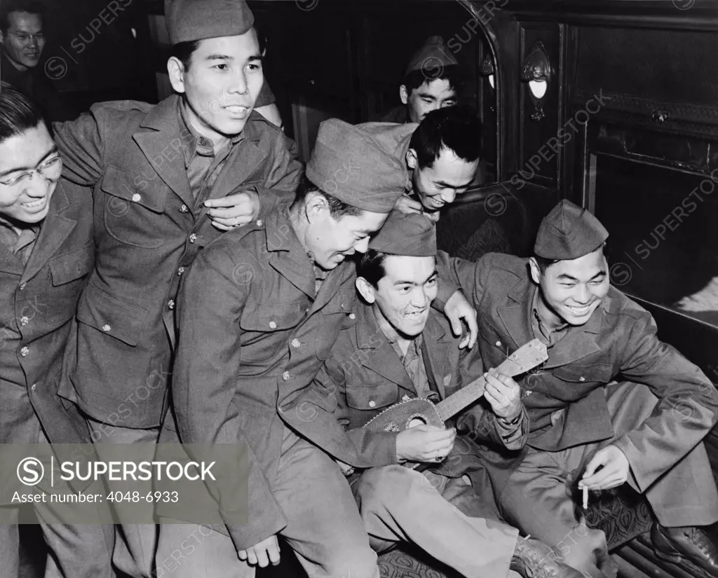 Japanese American soldiers enjoy the music of a Hawaiian ukulele as they wait to detrain at Camp Shelby, Mississippi in 1943. While some Japanese volunteered for military service, a significant and often under reported umber choose to not to.
