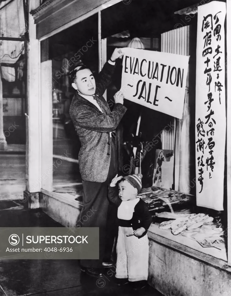 Japanese-American merchant posts a sale sign on his San Francisco store in preparation for internment. Internees were given little notice and forced to abandon or sell their businesses at heavy losses.