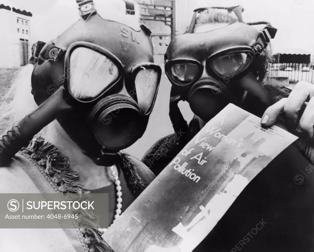 Mrs. Margaret Klein and Mrs. Marvin Blumenfeld, wearing gas masks, as they pass out a health bulletin, A WOMANS VIEW OF AIR POLLUTION at the Kiel Auditorium in St. Louis. 1966
