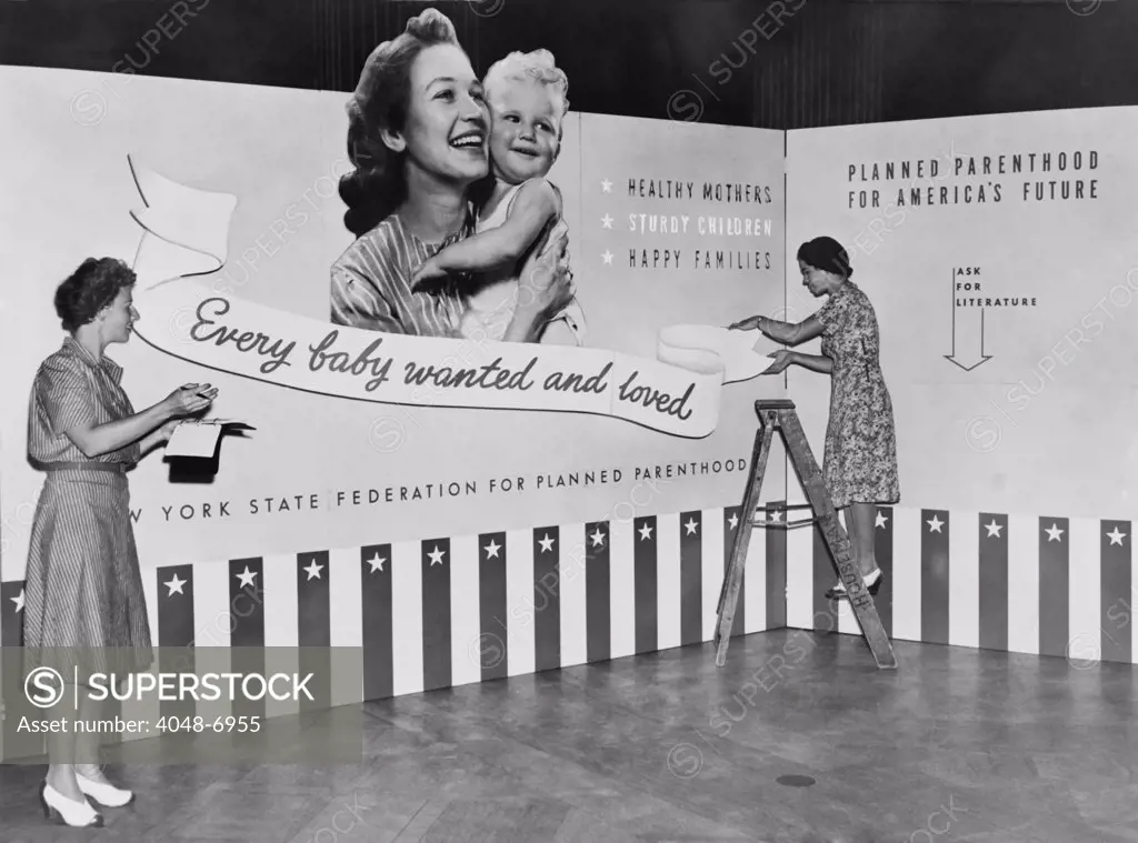 Two women working on panels for exhibit on planned parenthood featuring the slogan, 'Every baby wanted and loved'. Planned Parenthood was the new name of American Birth Control League, founded by Margaret Sanger in 1921.