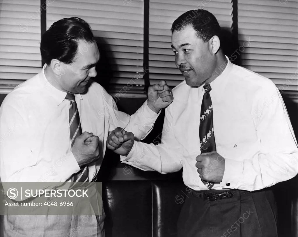 Joe Louis and Max Schmeling mock box with each other while wearing white shirts and ties, Chicago. They were iconic rivals in the 1930's, but formed a strong friendship in the post war years.