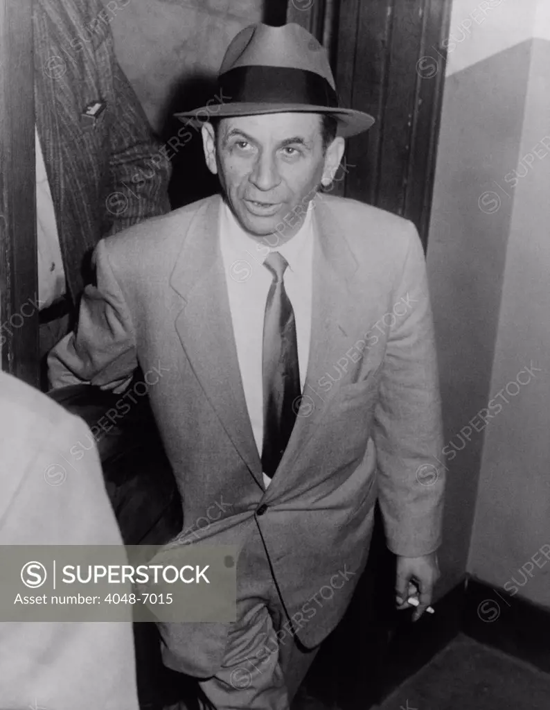 Gambling boss Meyer Lansky (1902-1983), led by a detective for booking on vagrancy charge at 54th Street police station, New York City, February 13, 1958.