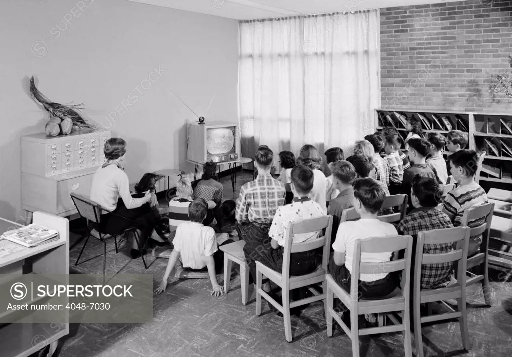 Students and their teacher watch educational television in a school library in Schenectady, New York, 1954.