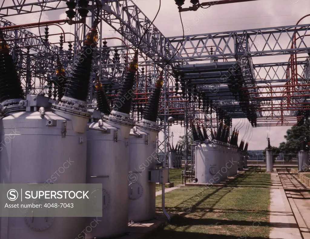 Switchyard at TVA's Wilson Dam hydroelectric plant, near Sheffield, Alabama. A series of electrical transformers topped with ceramic insulators, transfer power from the generation system of the Wilson Dam to the distribution system that delivered power to consumers. 1942.