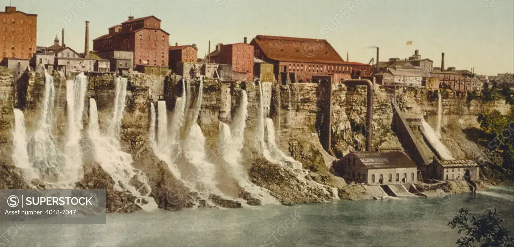 A cluster of factories built on and into the walls of the Niagara River Gorge. Water diverted from above the great Niagara Falls flows from the factories power generation plants. Ca. 1895.