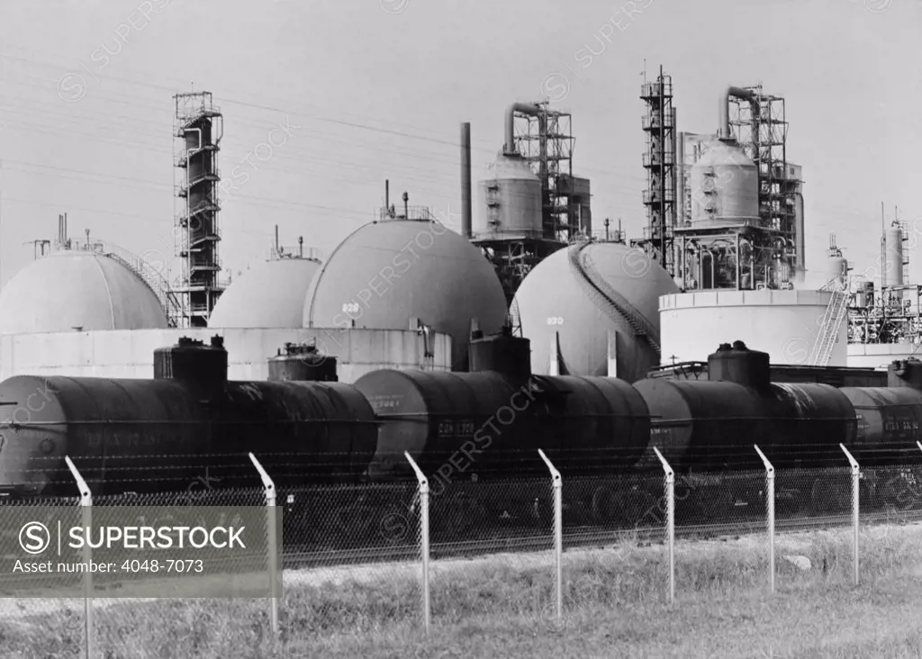 Railroad tank cars at an United States oil refinery to receive  gasoline stored in large spherical tanks. Ca. 1944.