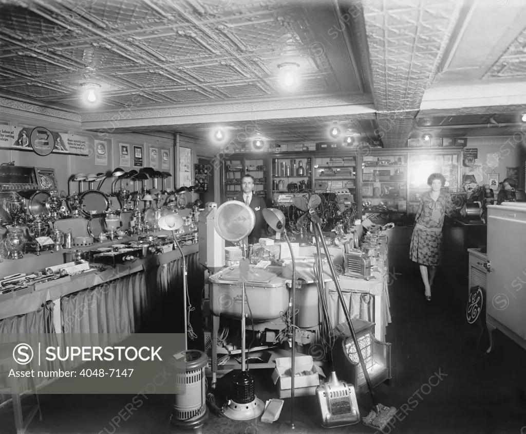 1920's showroom of Schneider Electric Store in Washington, D.C. Among the electric consumer products on display include: lamps, fans, space heaters, floor cleaners, clothes washers, refrigerators, toy trains, percolators, hotplates, toasters, irons and hair wavers. Westinghouse and General Electric brands are prominent.