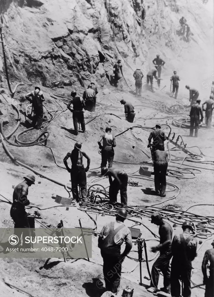 Drillers excavating the dam foundation on the Nevada side of Boulder dam, excavating the dam foundation. 1933.