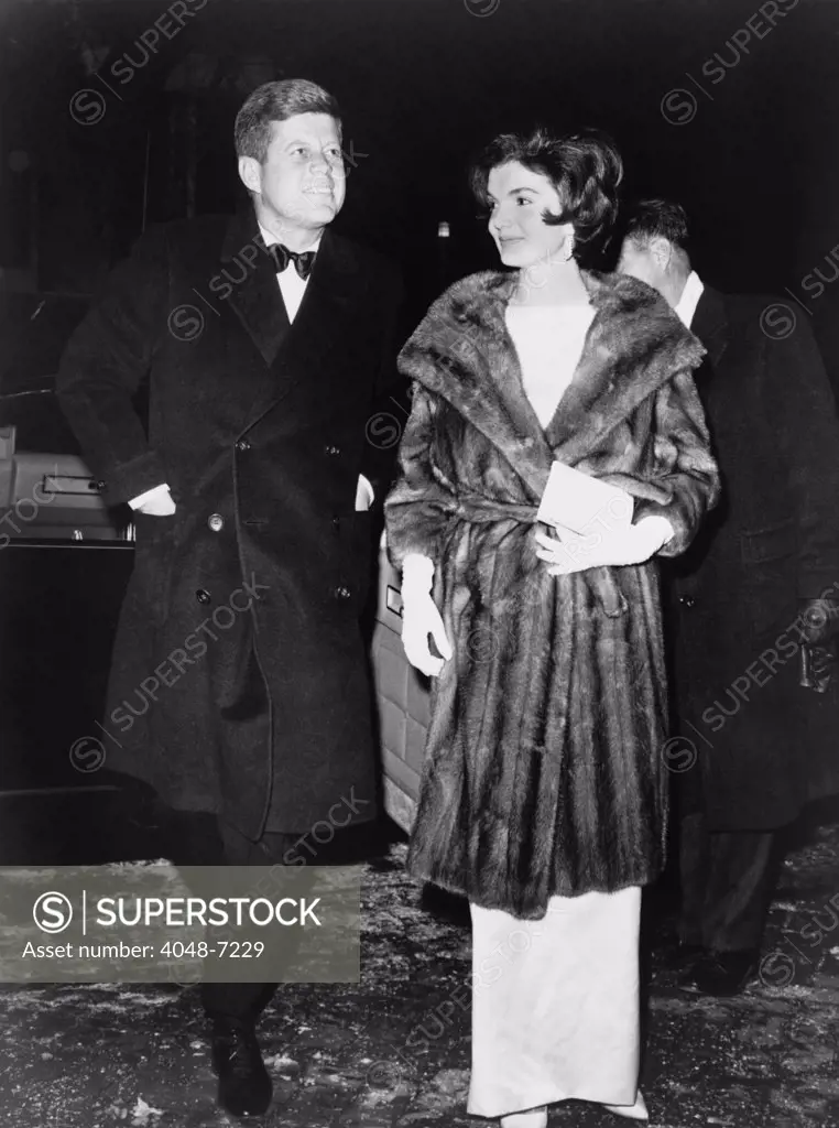 President and Mrs. Kennedy en route to a private party on March 7, 1961. On the cold winter night, Jacqueline Kennedy wears a mink coat.