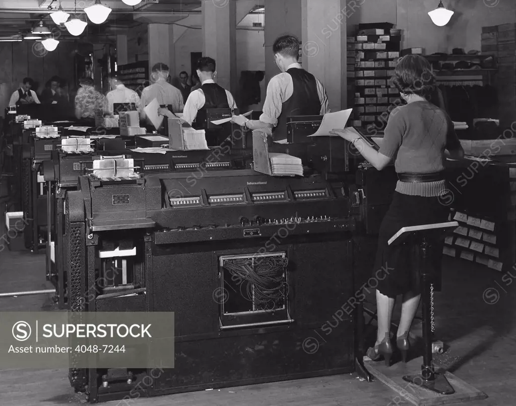 Social Security Administration clerks seated at massive tabulating machines, actually early computers, used to manage the individual records of millions of Americans in the Social Security system. Ca. 1940.