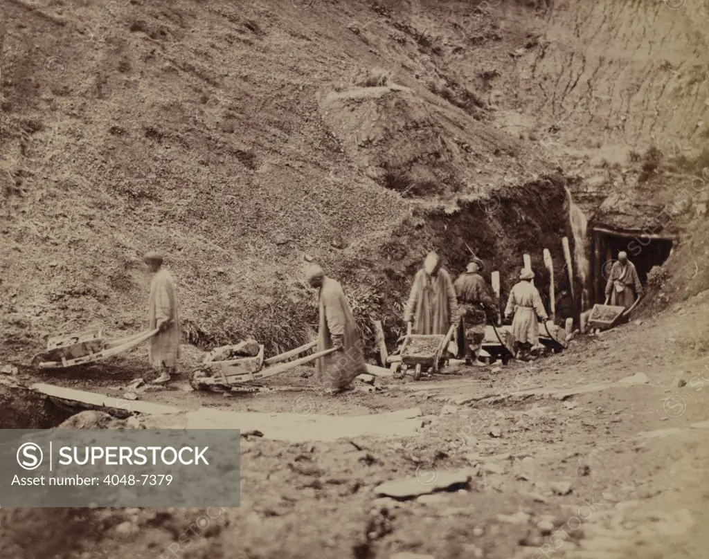 Turkestani workers hauling coal from an underground mine extracting coal close to the surface with pre-industrial methods used since ancient times.