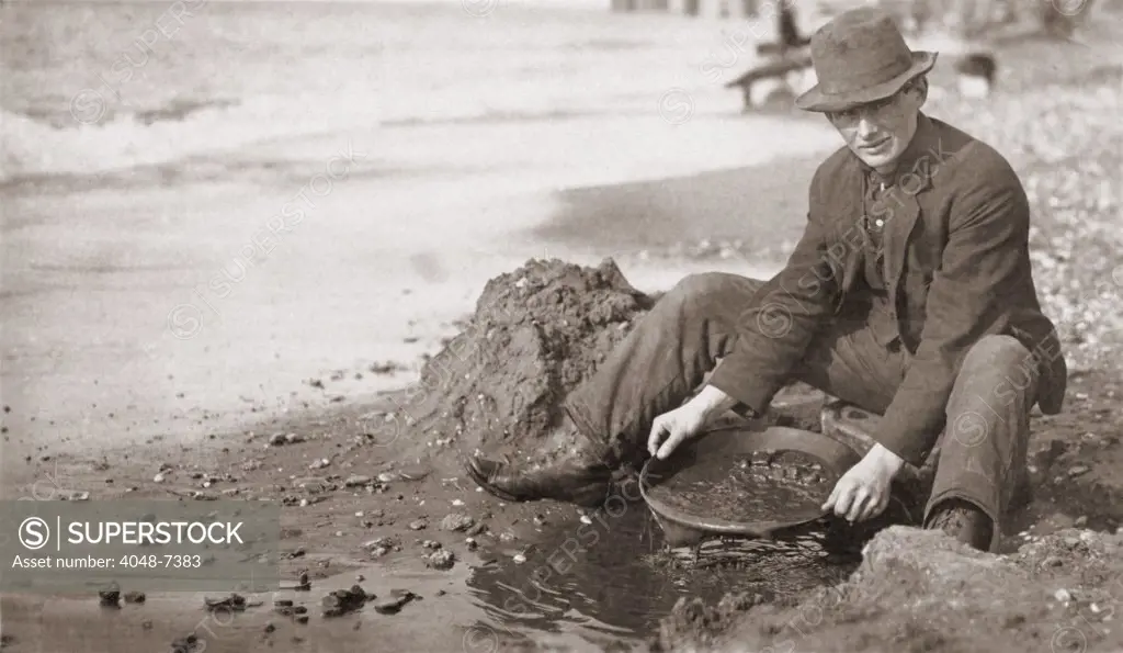 Man panning gold on Nome, Alaska, Beach in the early 20th century.