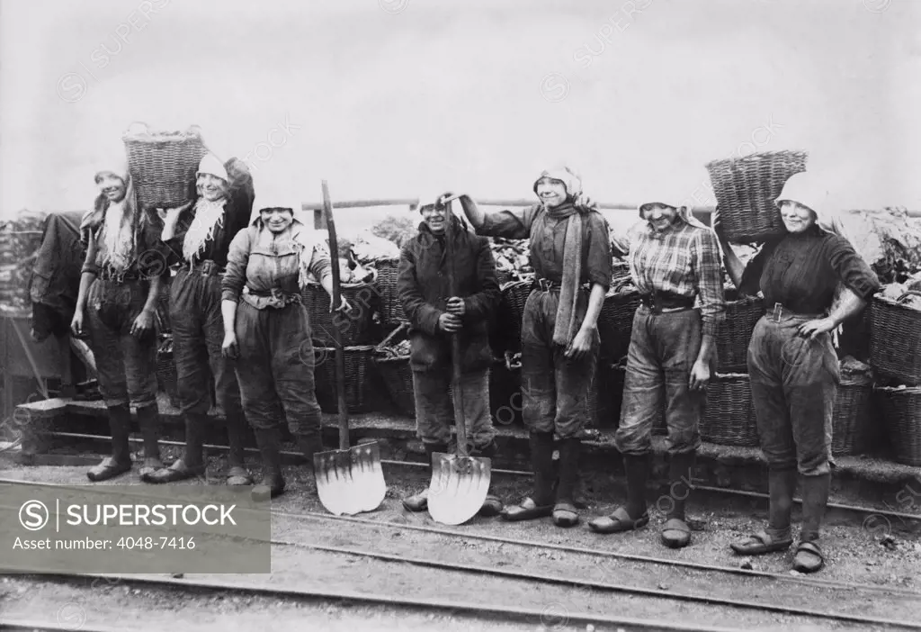 Belgian women coal miners dressed in trousers. They wear workers' clogs and headscarves, and tight belts that emphasize their waists. Between 1900-1920.