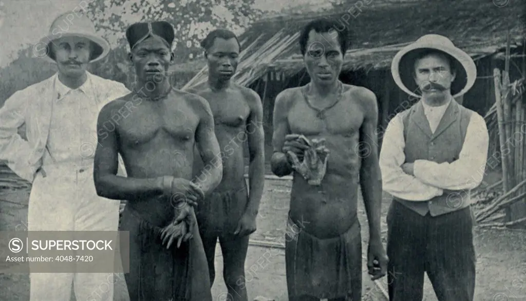 Atrocities of the Rubber Slavery in the Belgian Congo. Natives hold the severed hands of two countrymen murdered by rubber sentries in May 1904. The white men are Edgar Stannard and John Harris, Baptist missionaries, who documented many such atrocities for humanitarian activist Edward Morel.