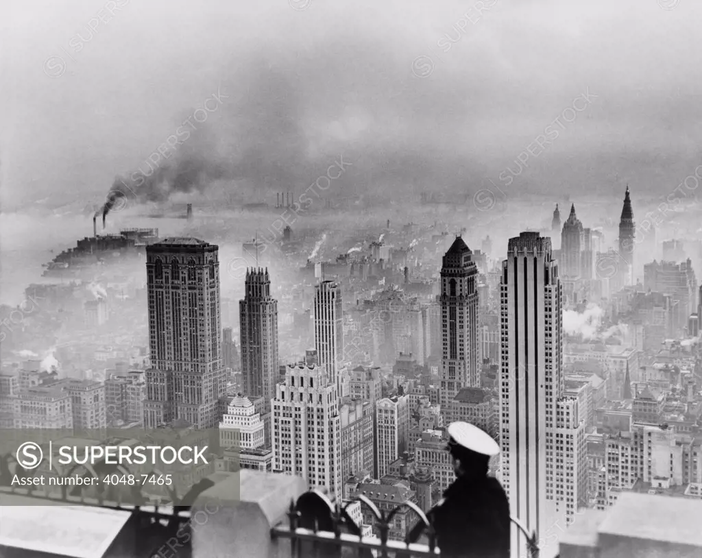 New York City under smog when weather conditions prevented smoke from dispersing. Southeast view from the Empire State Building includes the Lincoln Building at far left and the RCA Building at 500 Fifth Avenue on the far right. 1949 photo by Edward Ratcliffe.