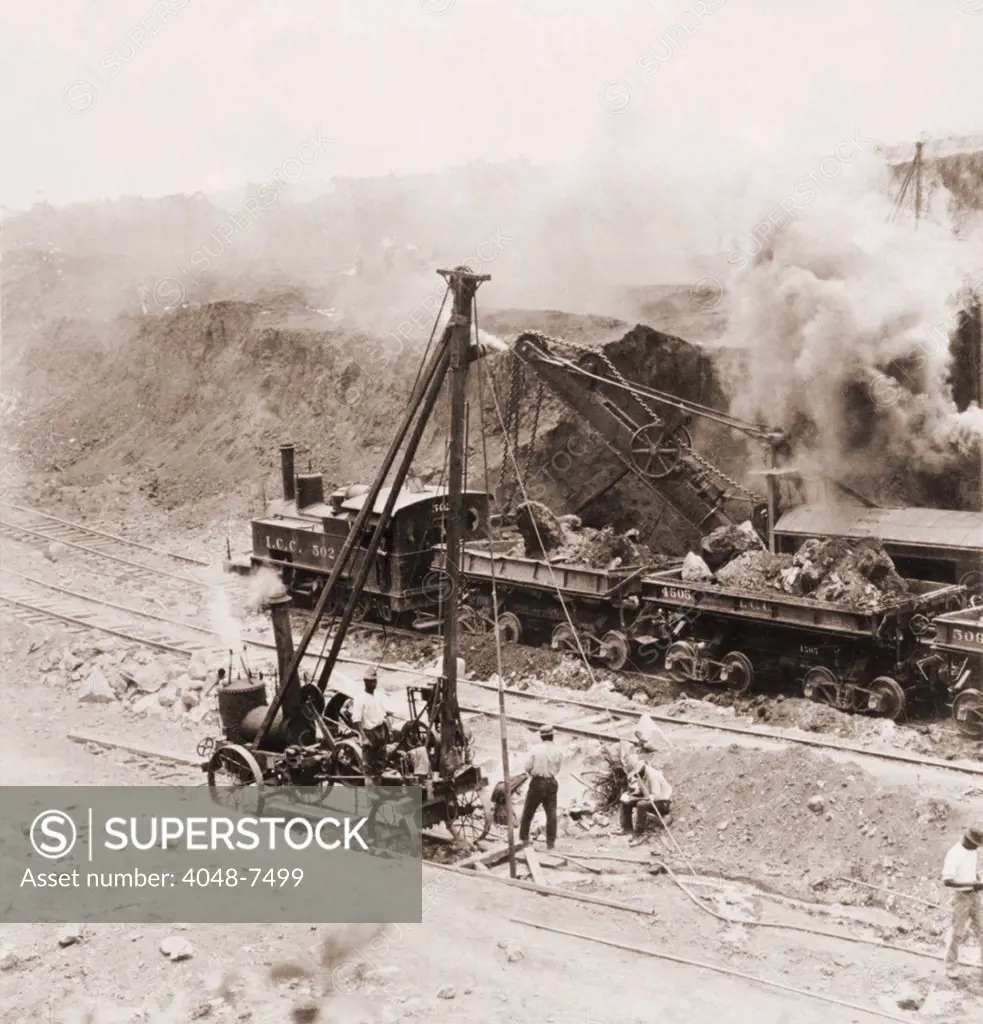 Panama Canal construction. A steam shovel loads excavated rocks into railroads cars at Gatun Dam site, Panama Canal Zone. 1910.