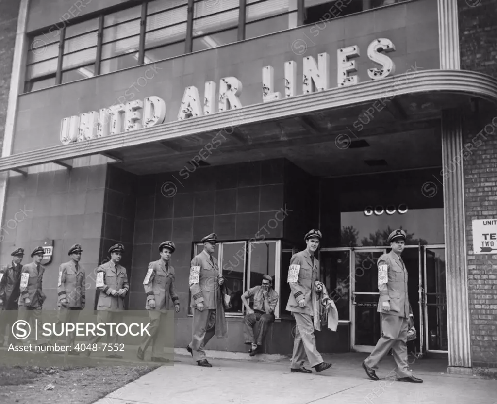 United Air Lines uniformed pilots form a picket line as they march past the airline's Chicago Midway terminal. 1951.