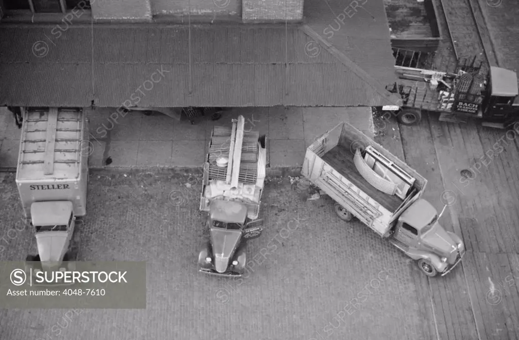 Overhead view of trucks loading at farm implement warehouse, Minneapolis, Minnesota, 1939.