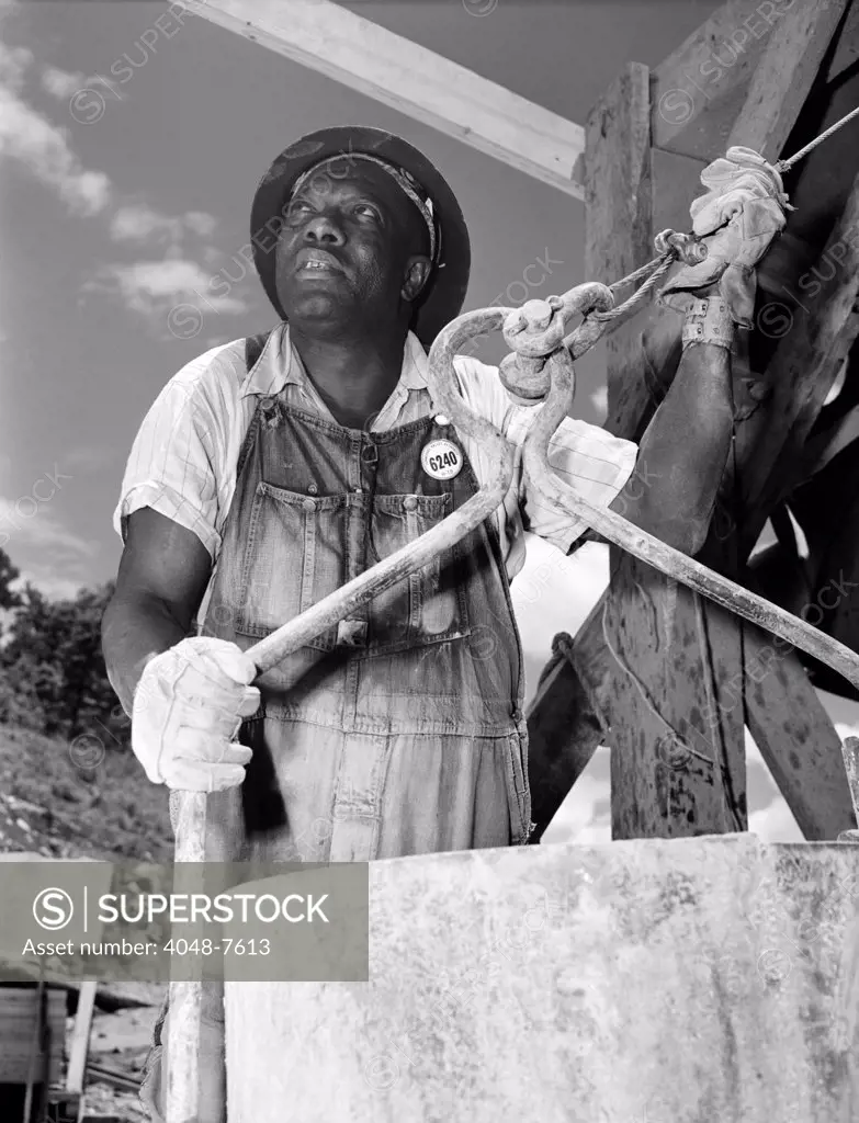 African American construction worker at the Douglas Dam on the French Broad River, one of the Tennessee Valley Authority public works projects of the New Deal. June 1942.